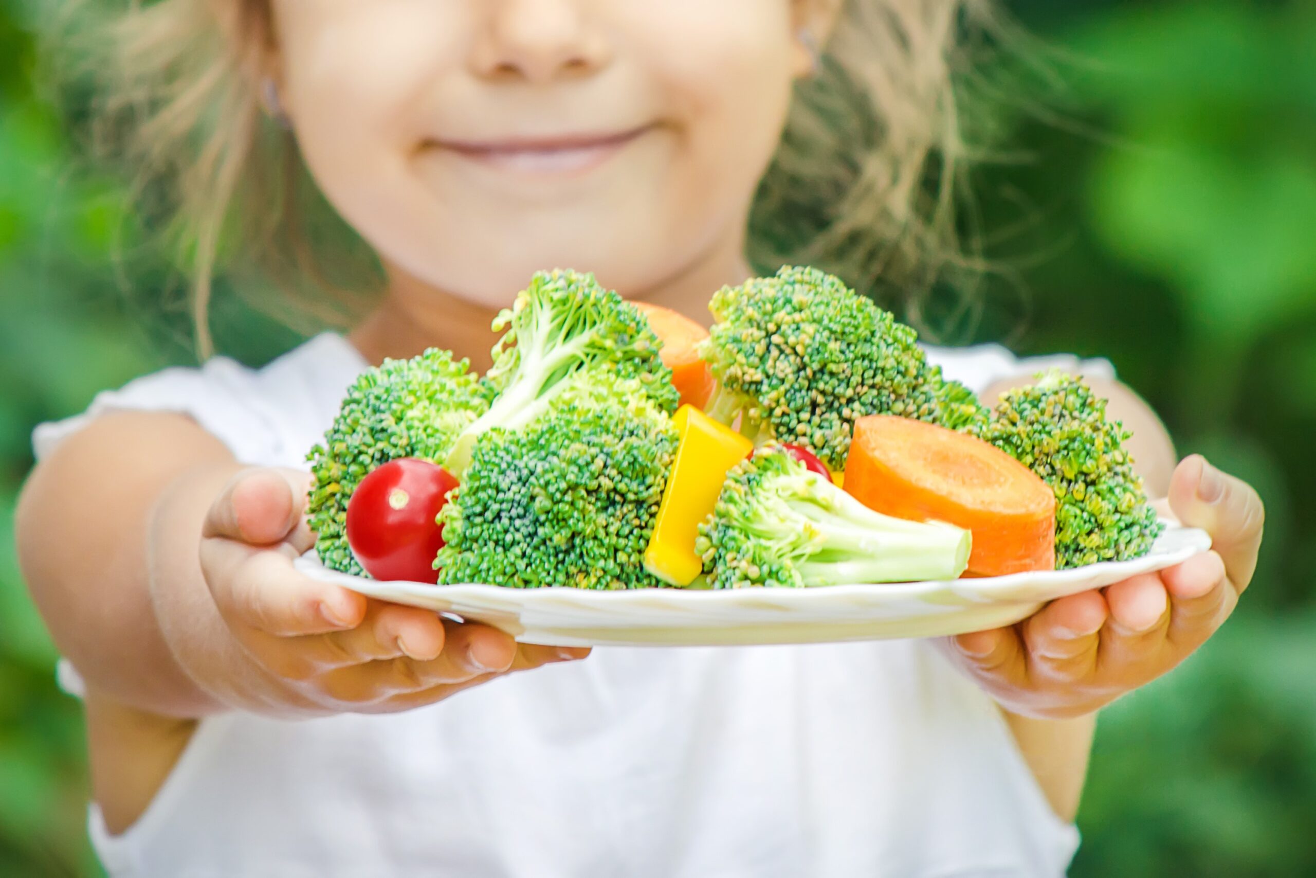 child eats plate of vegetables