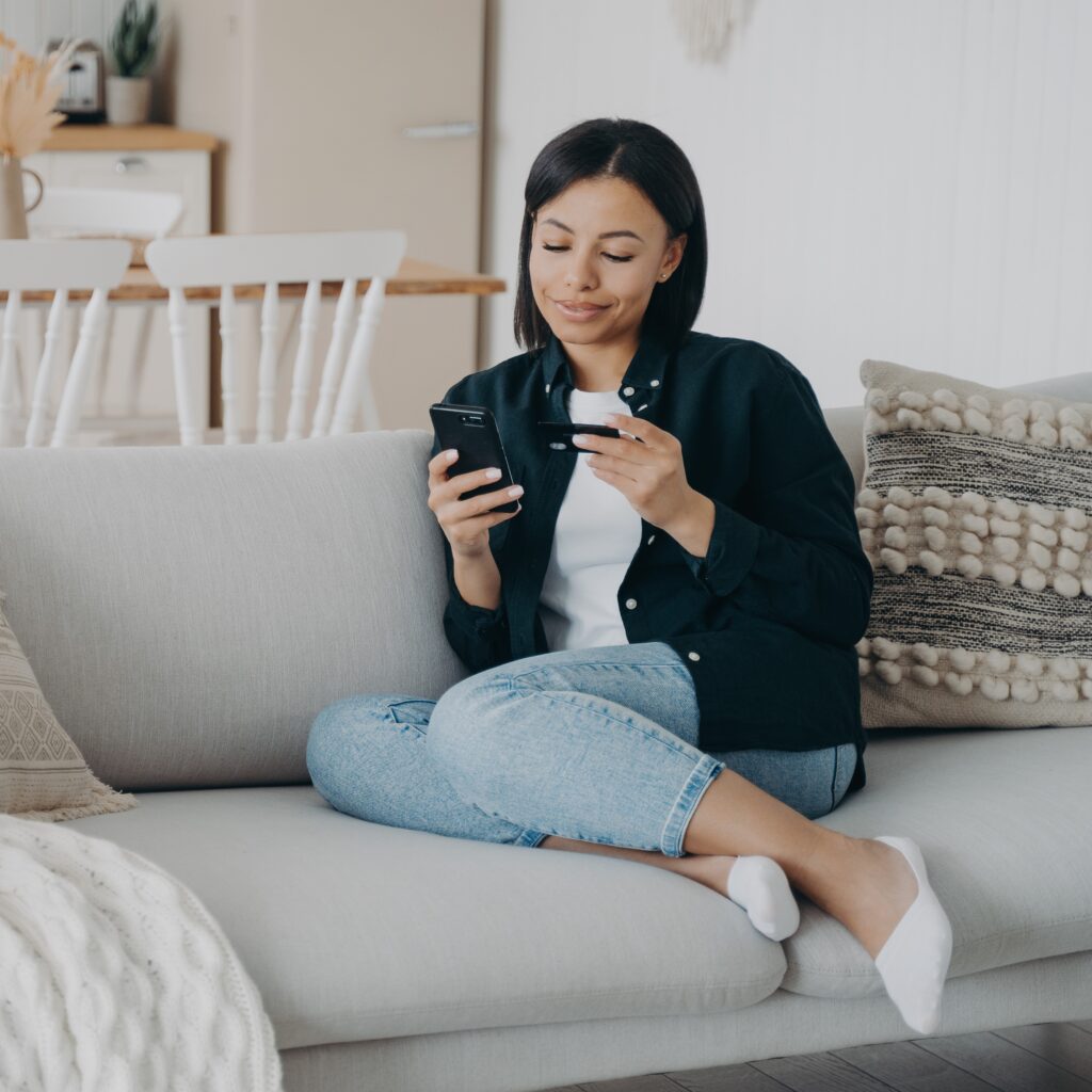 Woman making FCA approved online payments using mobile phone.