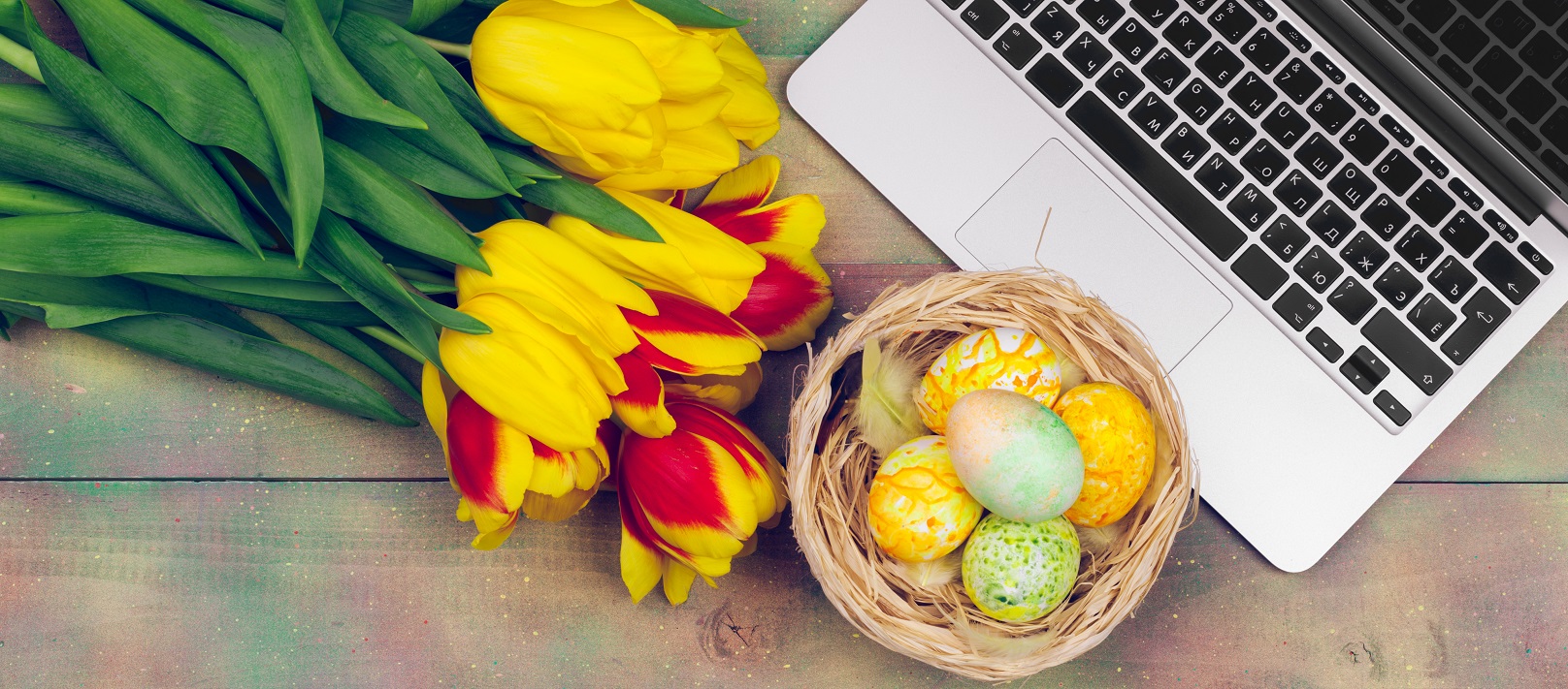 Easter eggs, mockup laptop and bouquet of tulips.