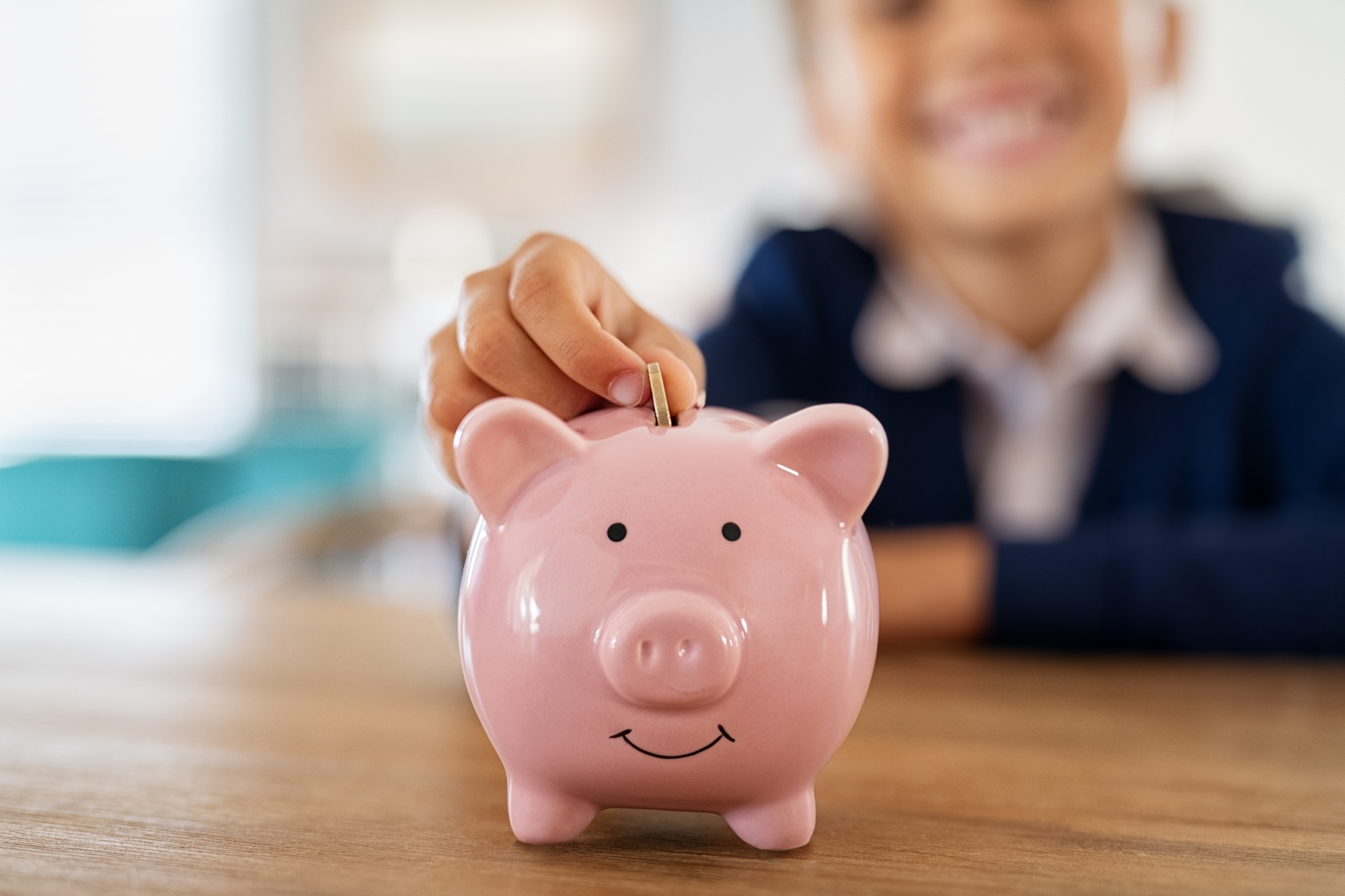 School child saving money in a piggy bank
